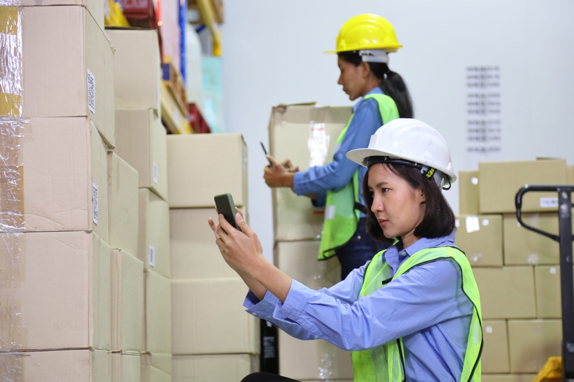 Two women scanning codes in warehouse